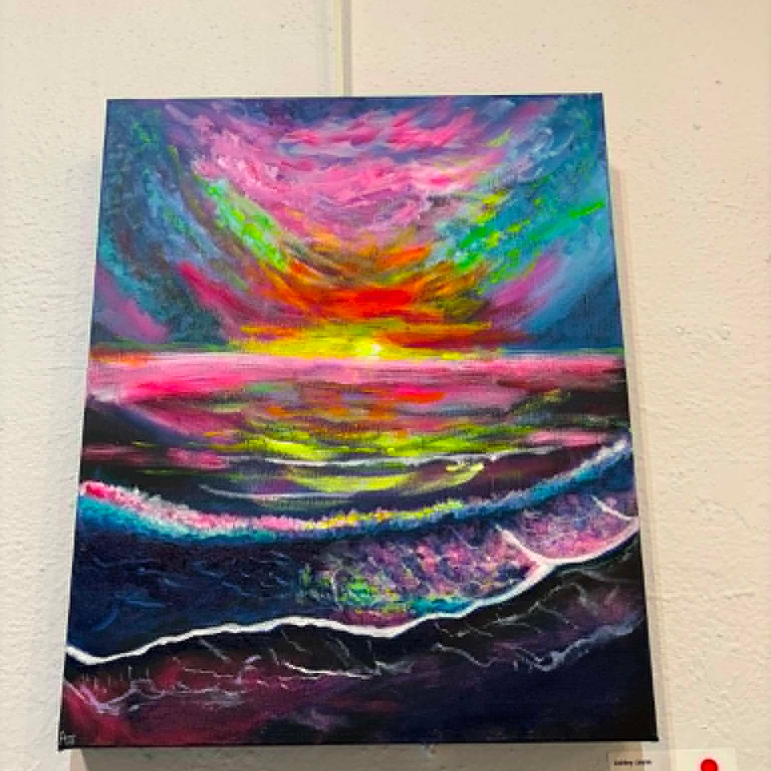 A colorful abstract painting of a sunset over the ocean, mounted on a white wall with a small label card below it.