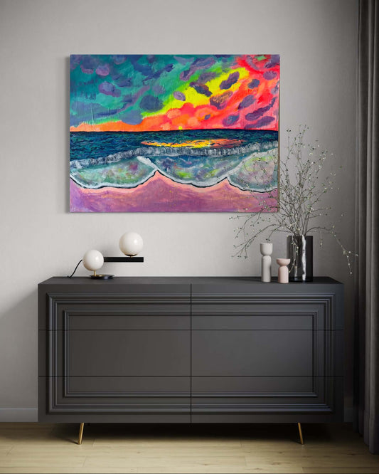 A colorful abstract seascape painting hangs on a light gray wall above a dark gray sideboard. The artwork features vivid blue, teal, yellow, pink, and red tones with waves and a bright horizon.